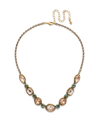 Cardoon Tennis Necklace - NDX7AGSTN - <p>A classic pattern comprised of a central oval crystal followed by cushion cut, emerald cut and navette stones, each separated with a shimmering round crystal. A rhinestone chain gives this necklace all-around allure From Sorrelli's Sandstone collection in our Antique Gold-tone finish.</p>